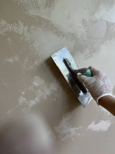 Decorative painter applying a custom faux painting finish to an interior wall