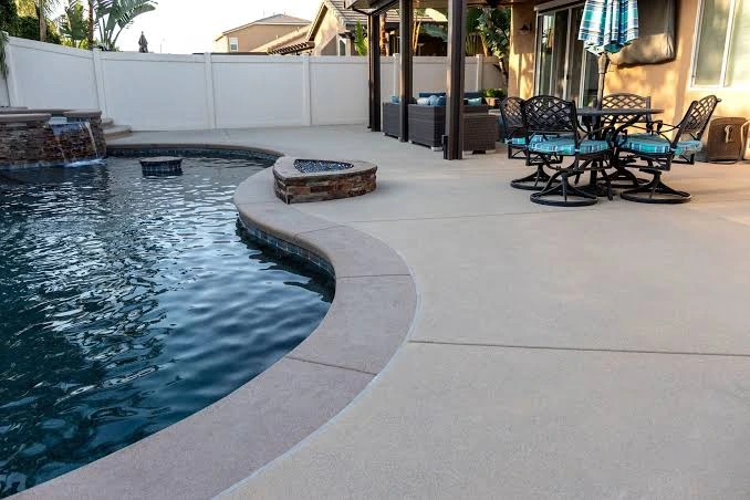 Outdoor swimming pool with a finished decorative concrete pool deck